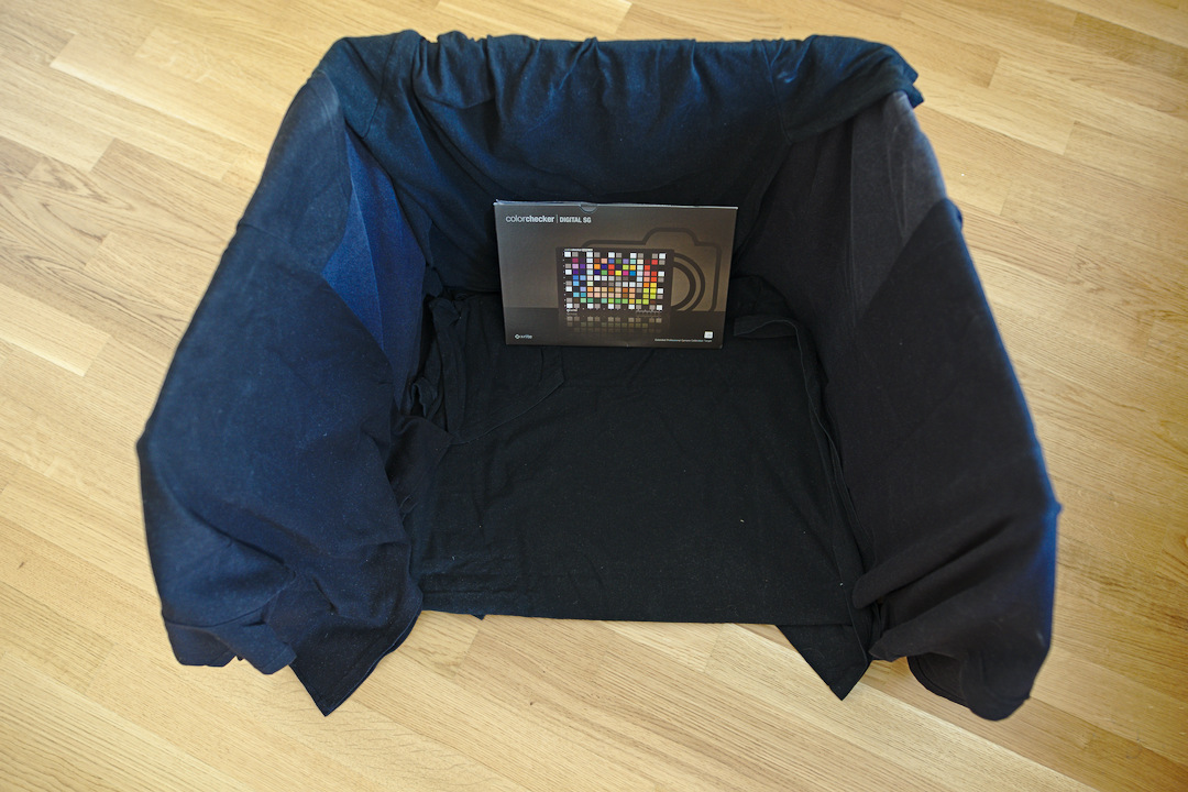 A cardboard box coated with black t-shirts